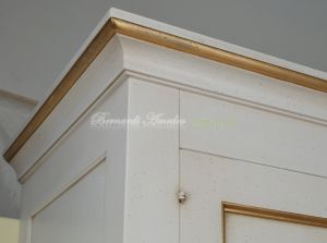 Classic wooden cabinet with white lacquered finish and hand-applied gold leaf